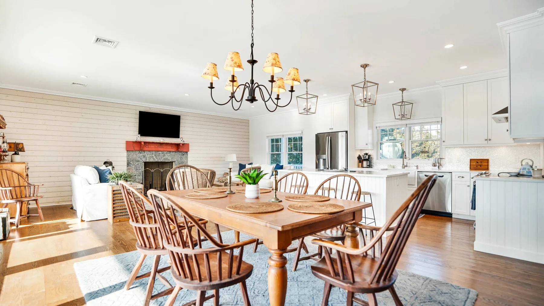 Una luminosa sala de estar y cocina de concepto abierto con una mesa de comedor de madera.