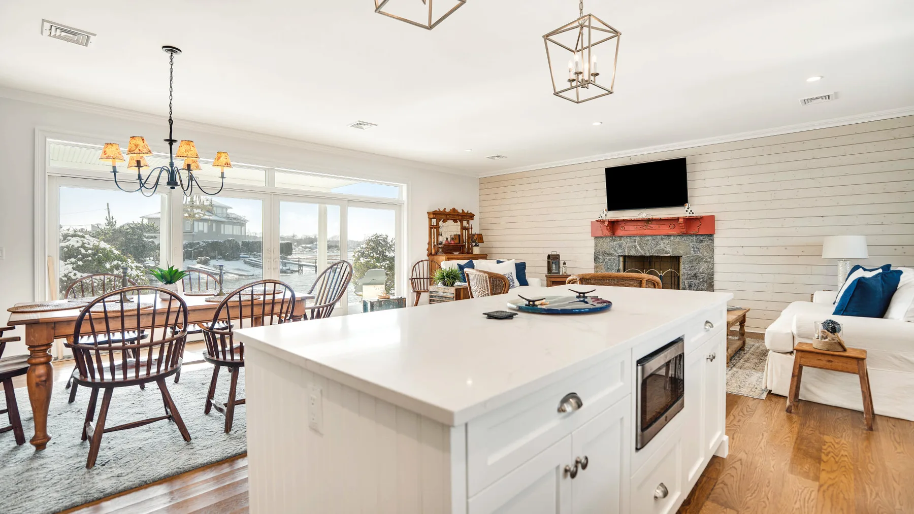 Una luminosa zona abierta de comedor y cocina con una gran isla blanca y una mesa de comedor.