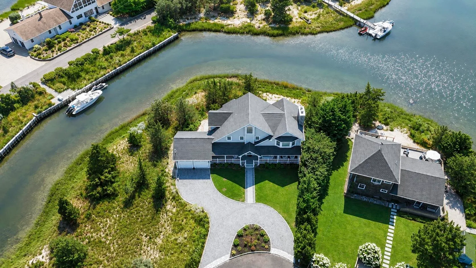 Vista aérea de una casa junto a un canal sinuoso, con una entrada curva.