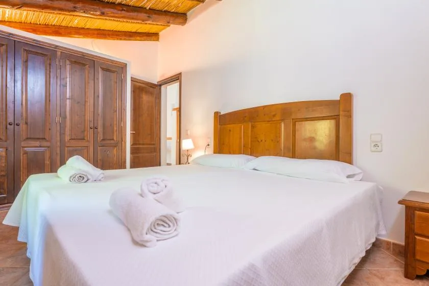 A bedroom with a large bed and wooden wardrobes.