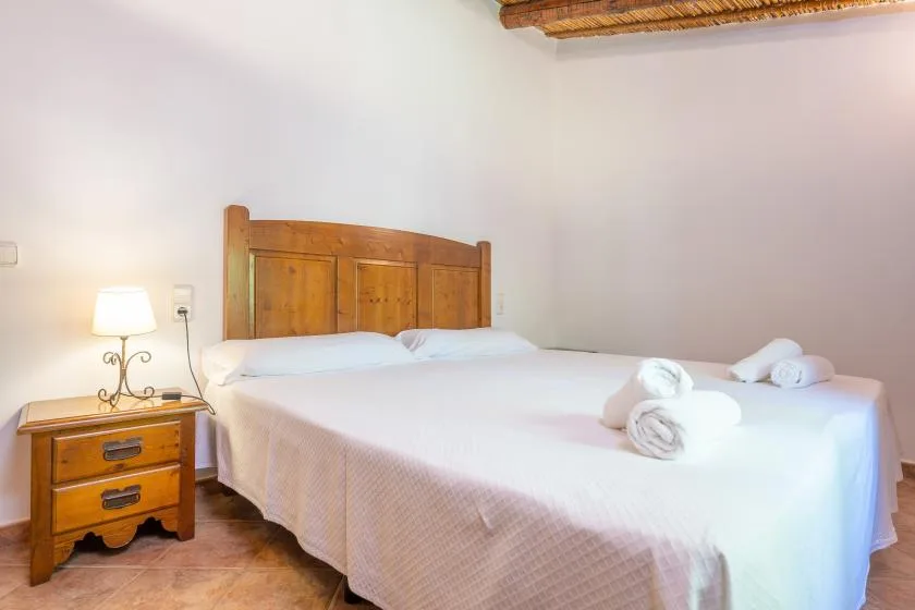 A bedroom with a wooden headboard and white bedding.