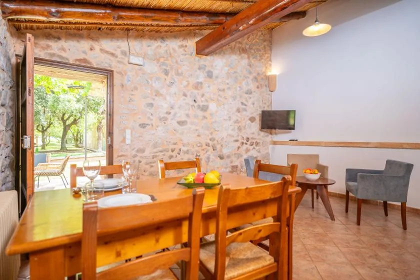 A dining area with a wooden table and chairs beside an open doorway to a patio.