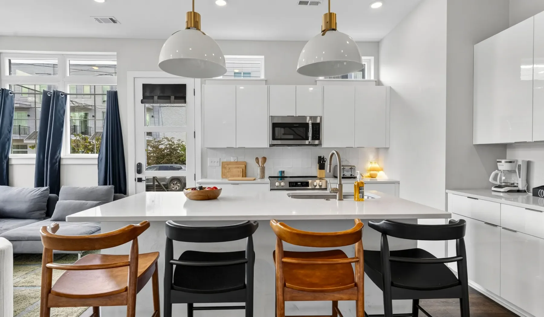 Una luminosa cocina abierta con comedor, una isla larga y asientos.
