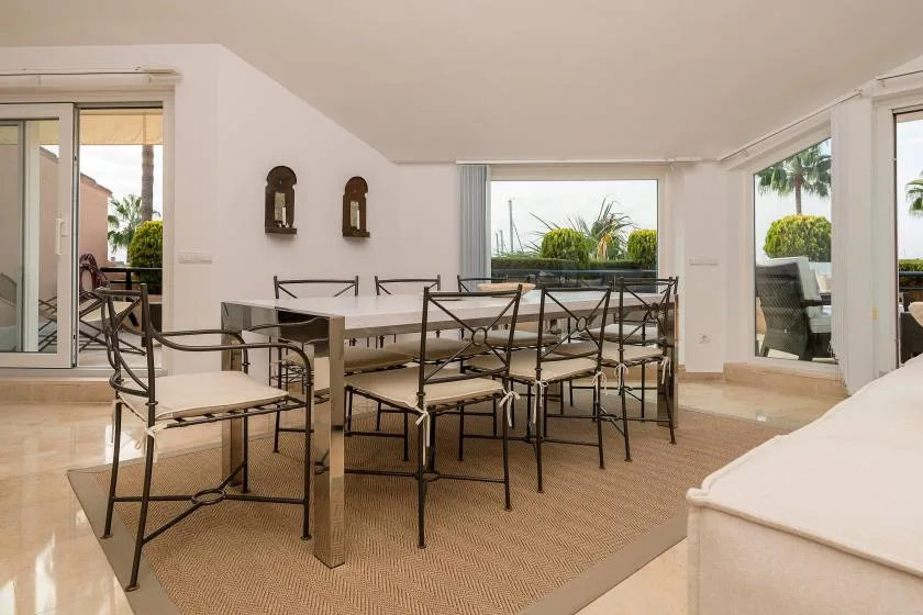 Un comedor luminoso con una mesa y asientos de estructura metálica.
