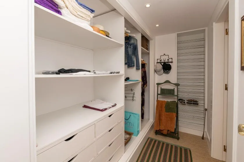 Un vestidor con estantes abiertos y ropa colgada.