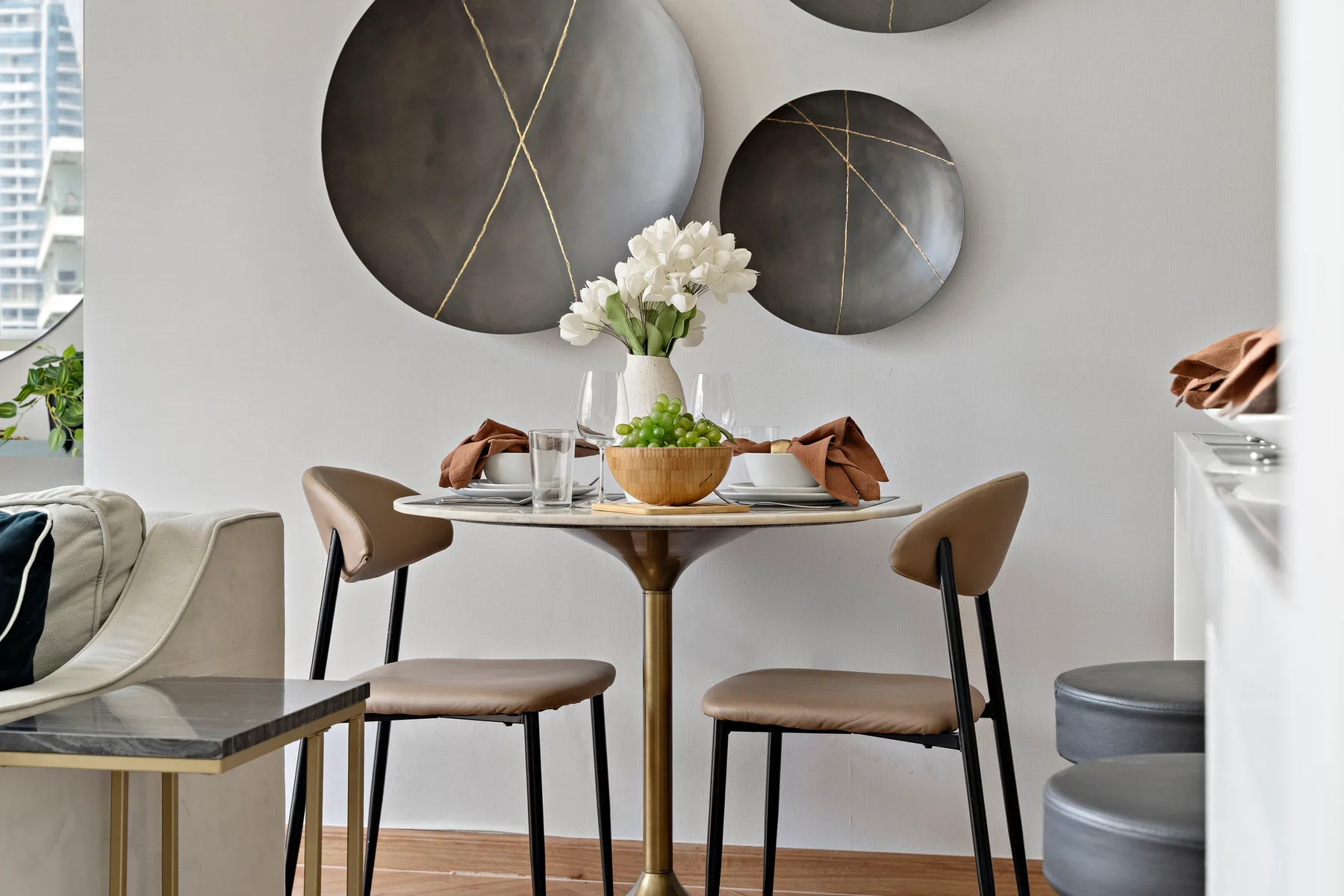 A dining area with a round table, chairs, and circular wall art.