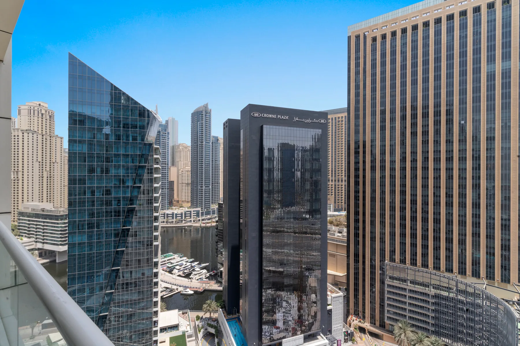 A city skyline seen from a balcony, with modern high-rise buildings and a canal.