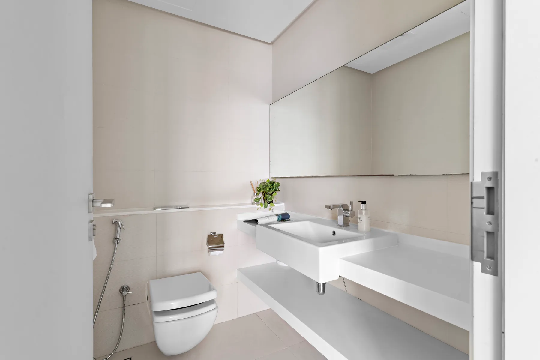 A modern bathroom with a wall-mounted sink and toilet.