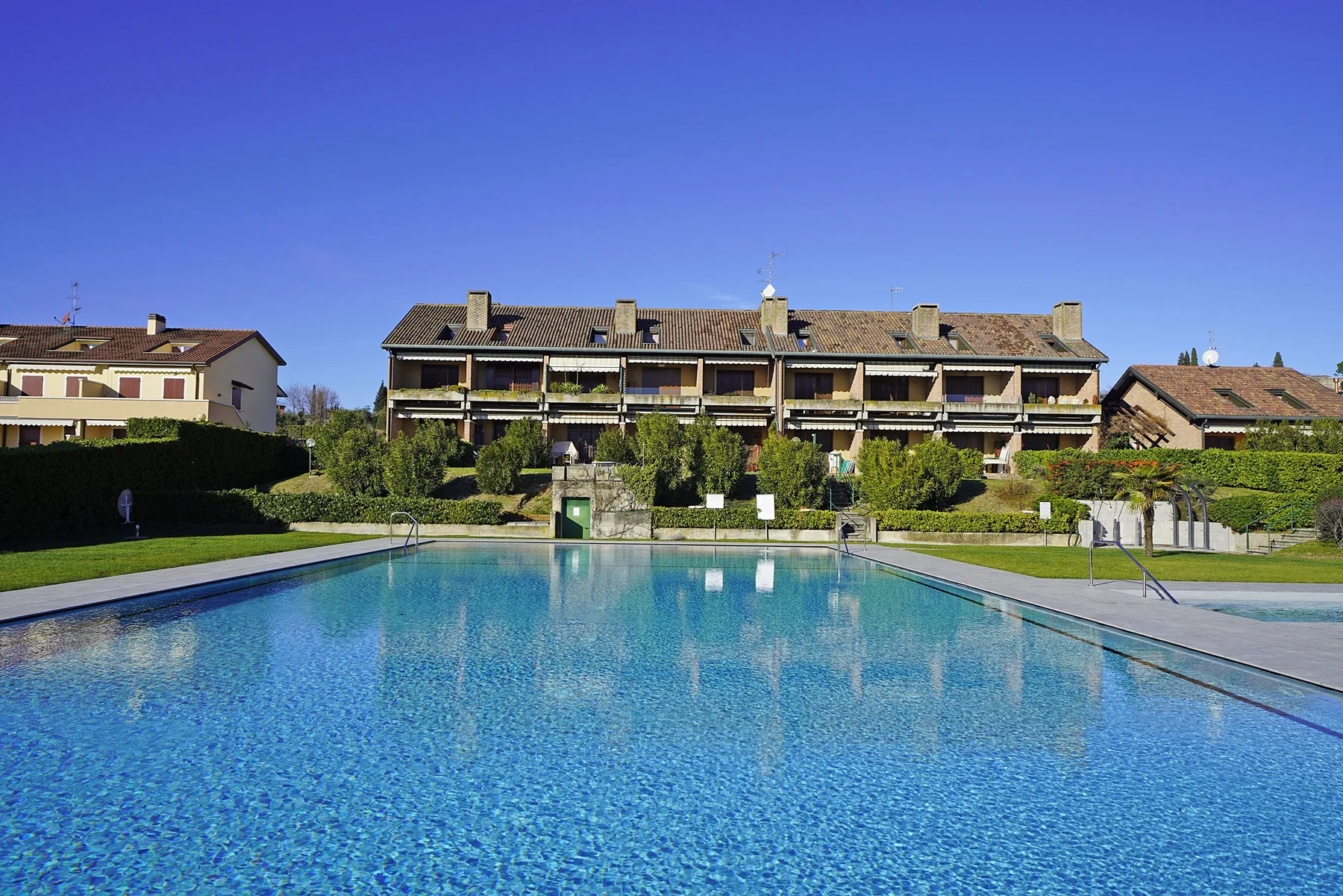 A swimming pool in front of a row of residential buildings.
