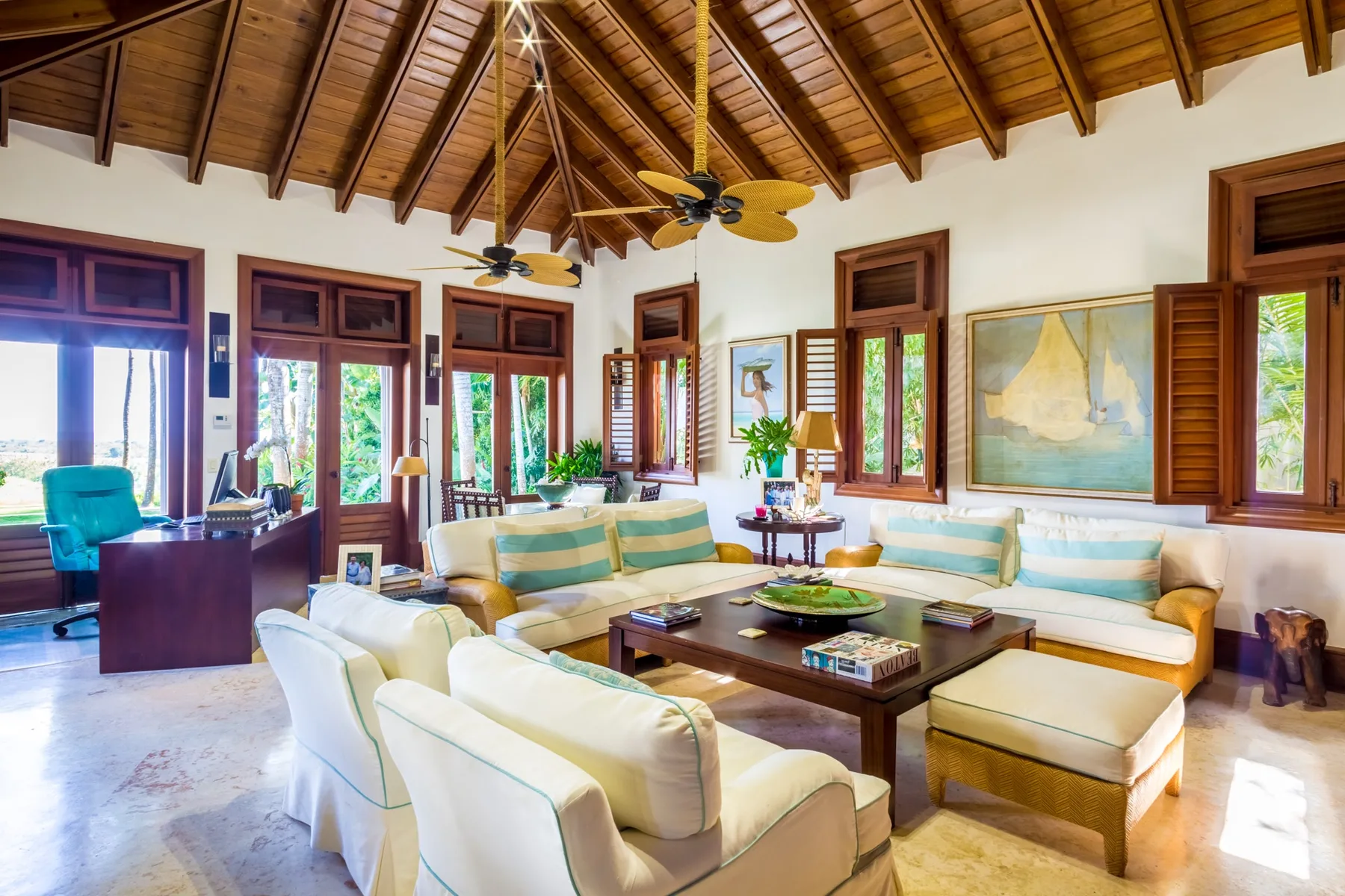 A bright living room with pale seating, a wooden coffee table, and large windows.