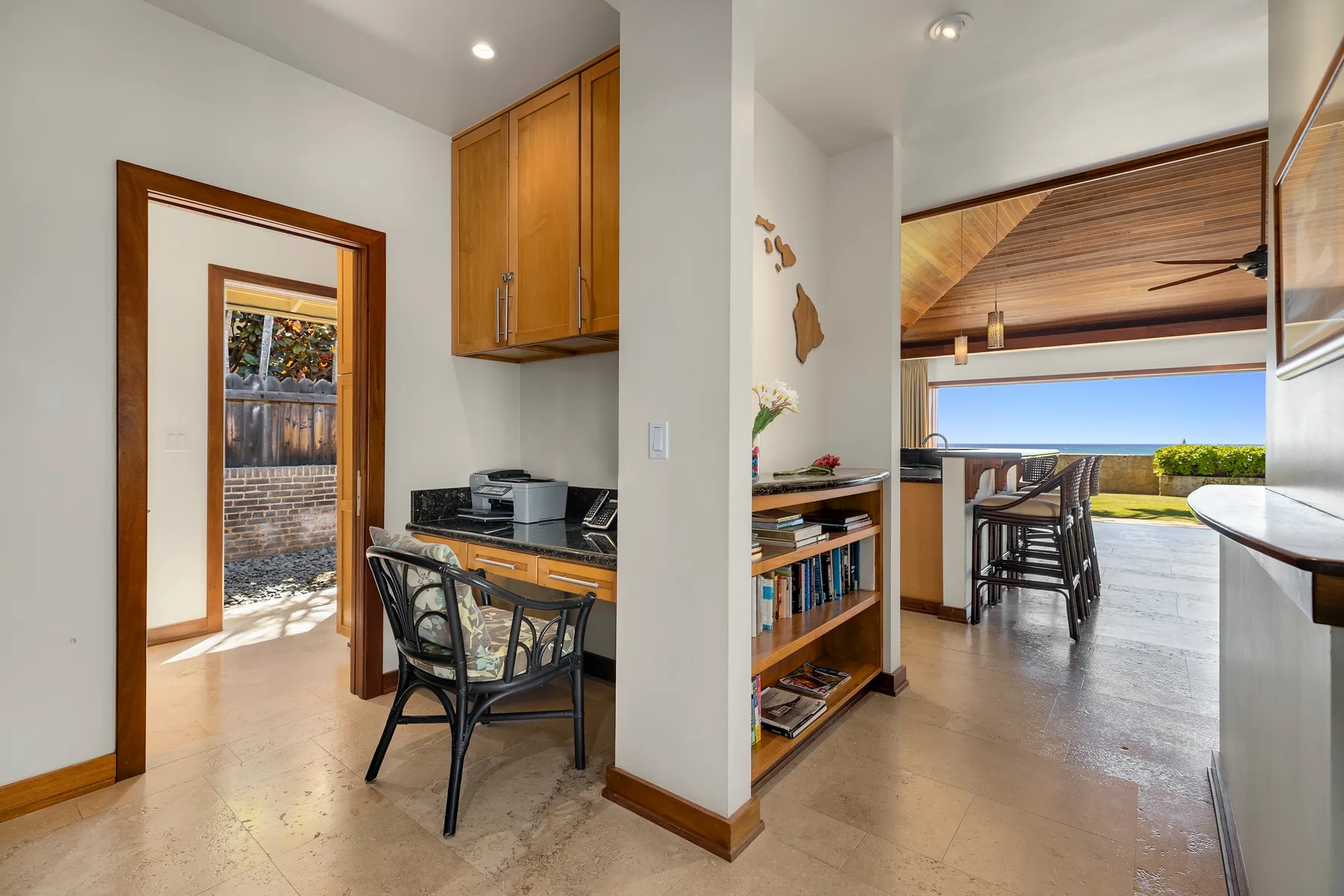 A kitchen and dining area open toward a patio overlooking the ocean.