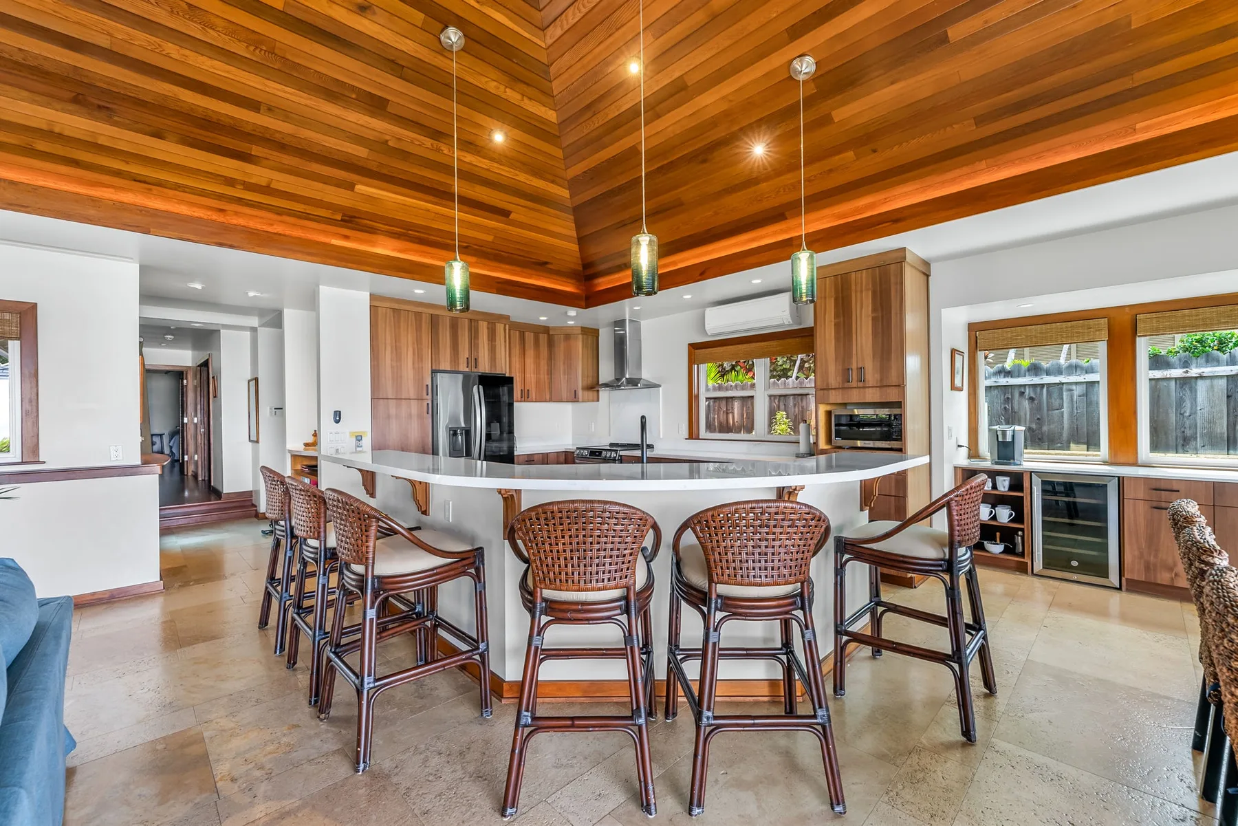 A spacious kitchen and dining area with a curved counter and wooden ceiling.