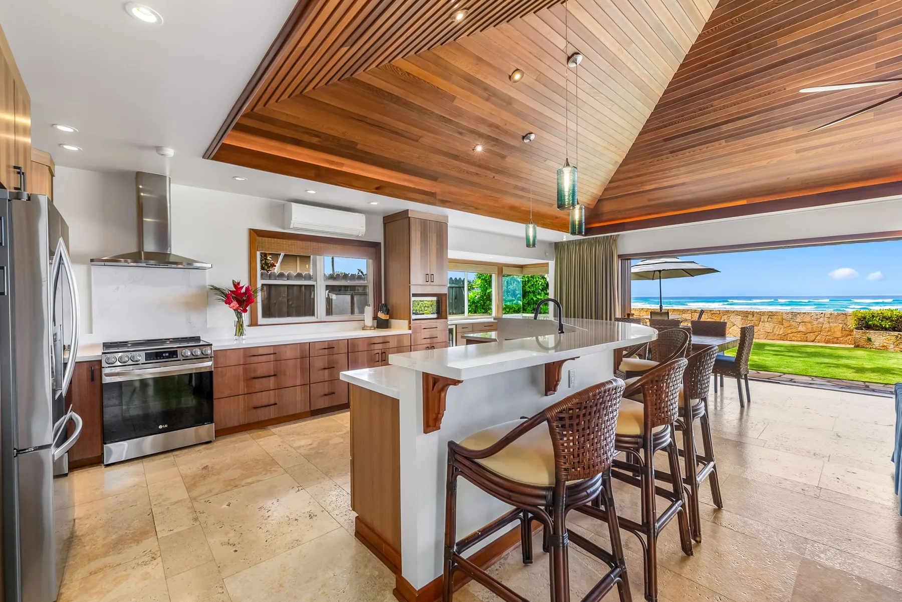 An open kitchen and dining area with a central island and views of the ocean.