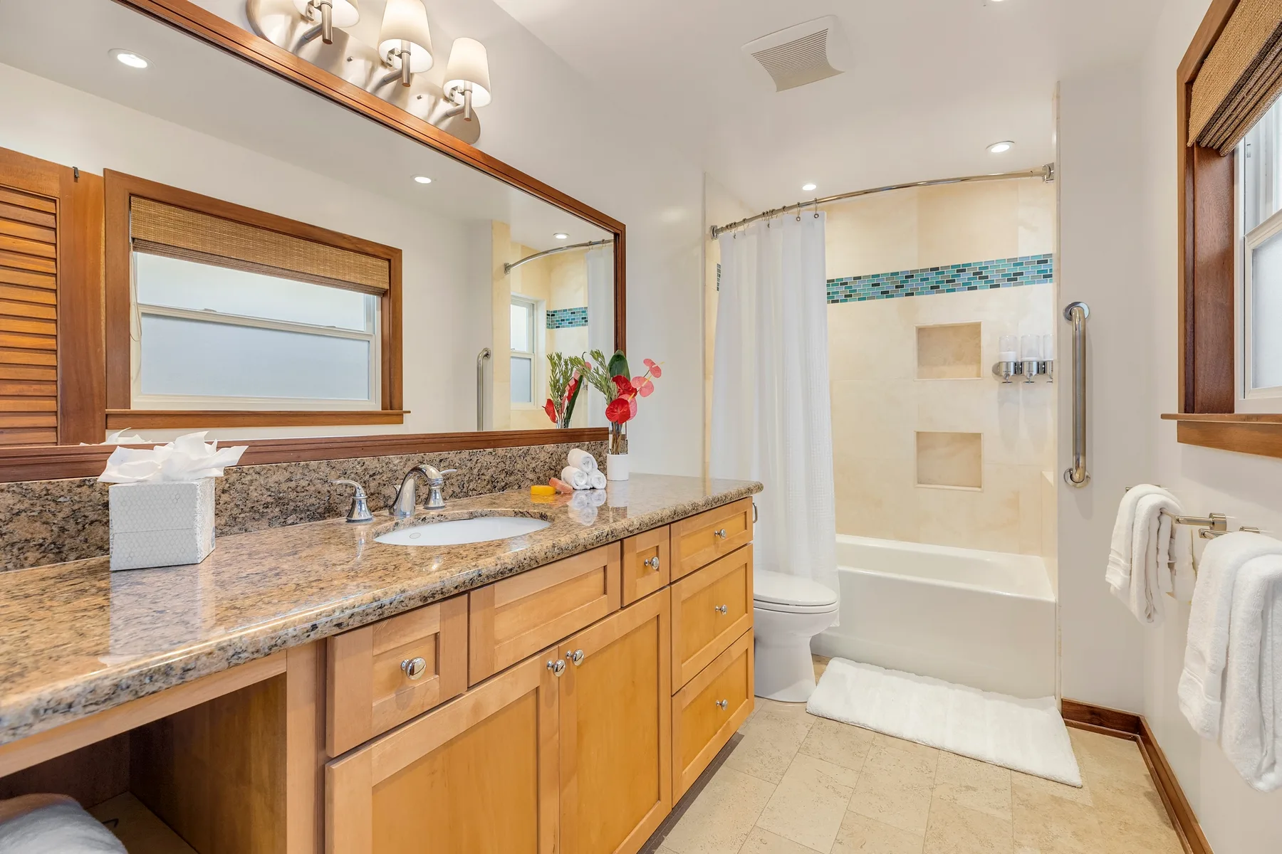A bathroom with a long vanity and a glass-enclosed shower.