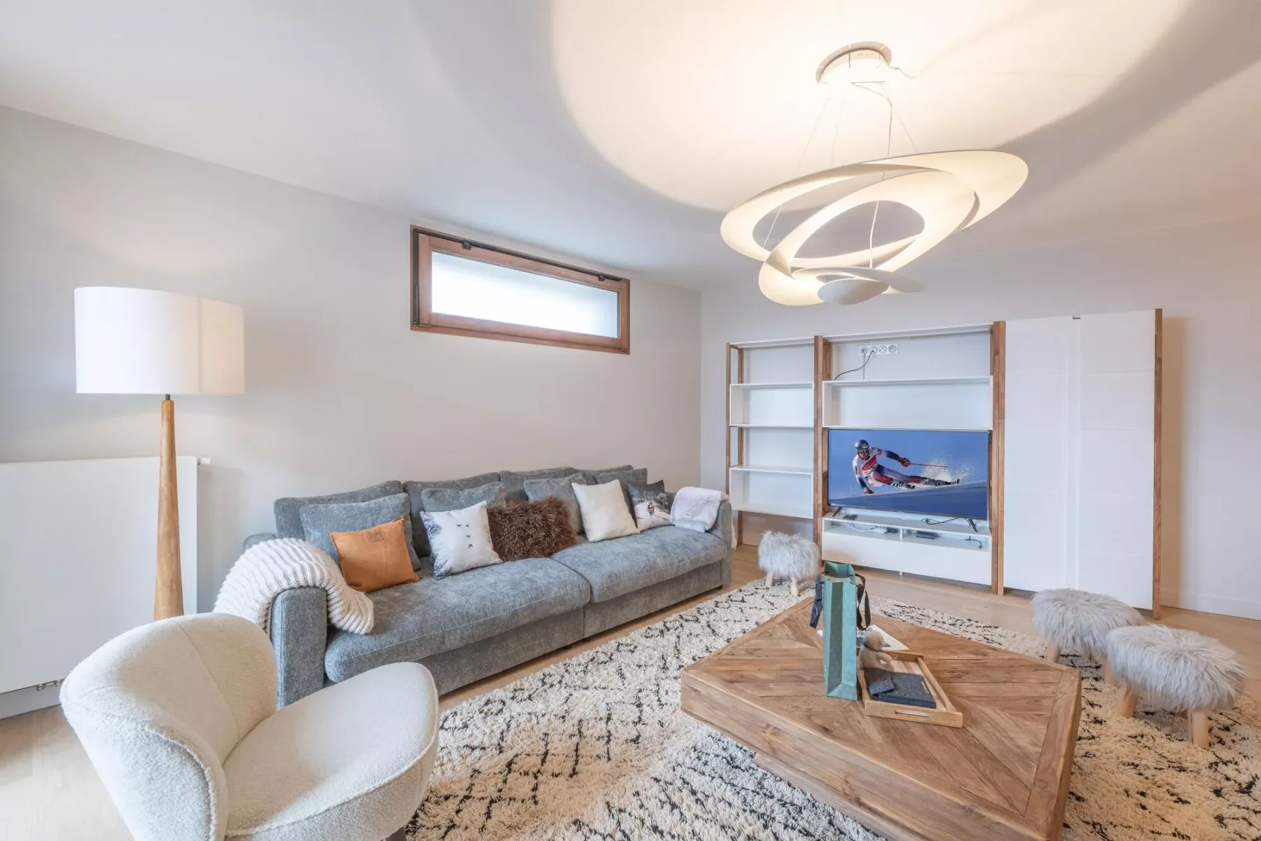 Living room with seating, a wooden coffee table, and a television.