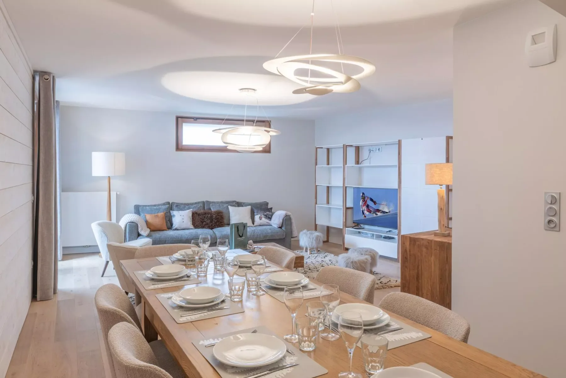 A bright dining and living area with a set table and seating.