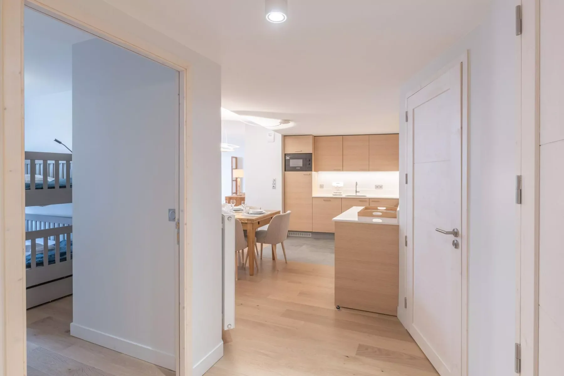 A bright kitchen and dining area with light wood cabinetry and a table.