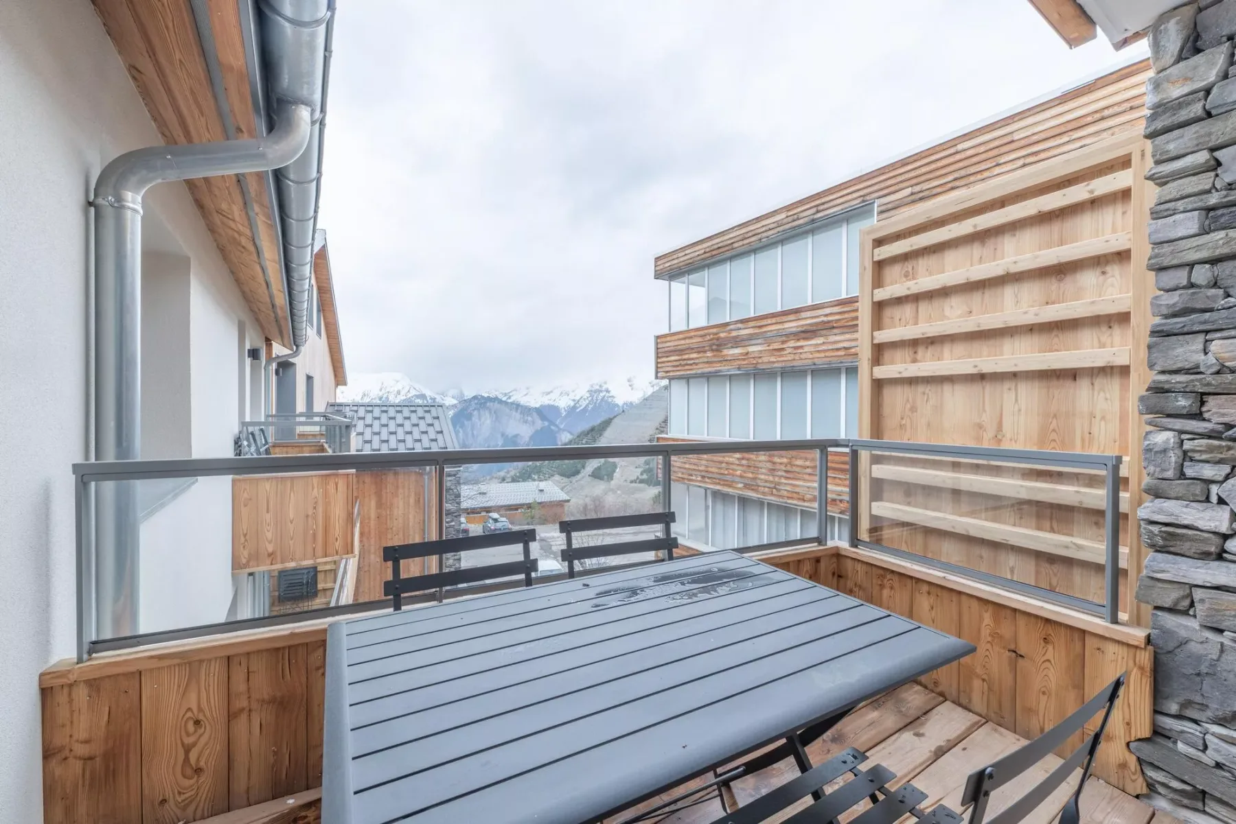 A balcony with an outdoor dining table and mountain views.