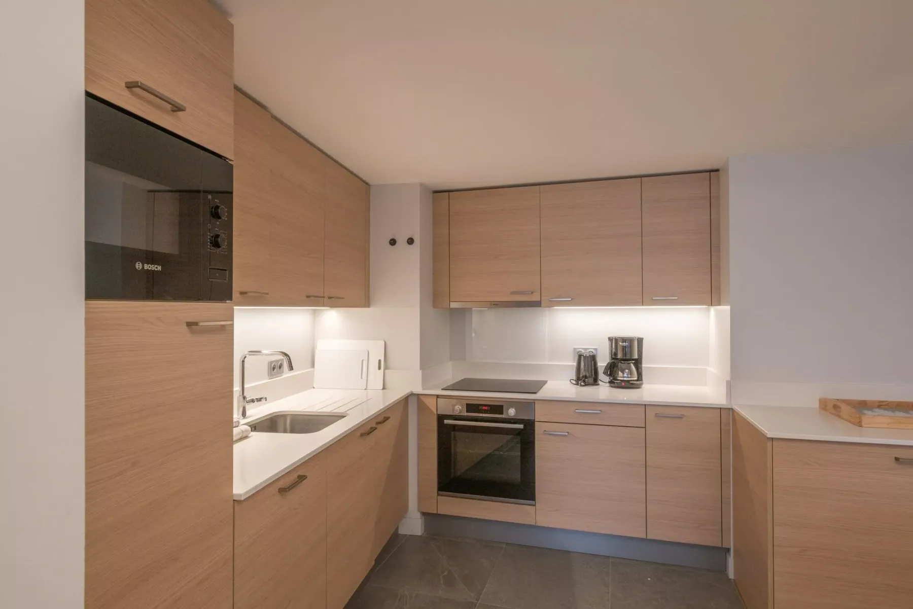 A modern kitchen with wood-toned cabinets and built-in appliances.