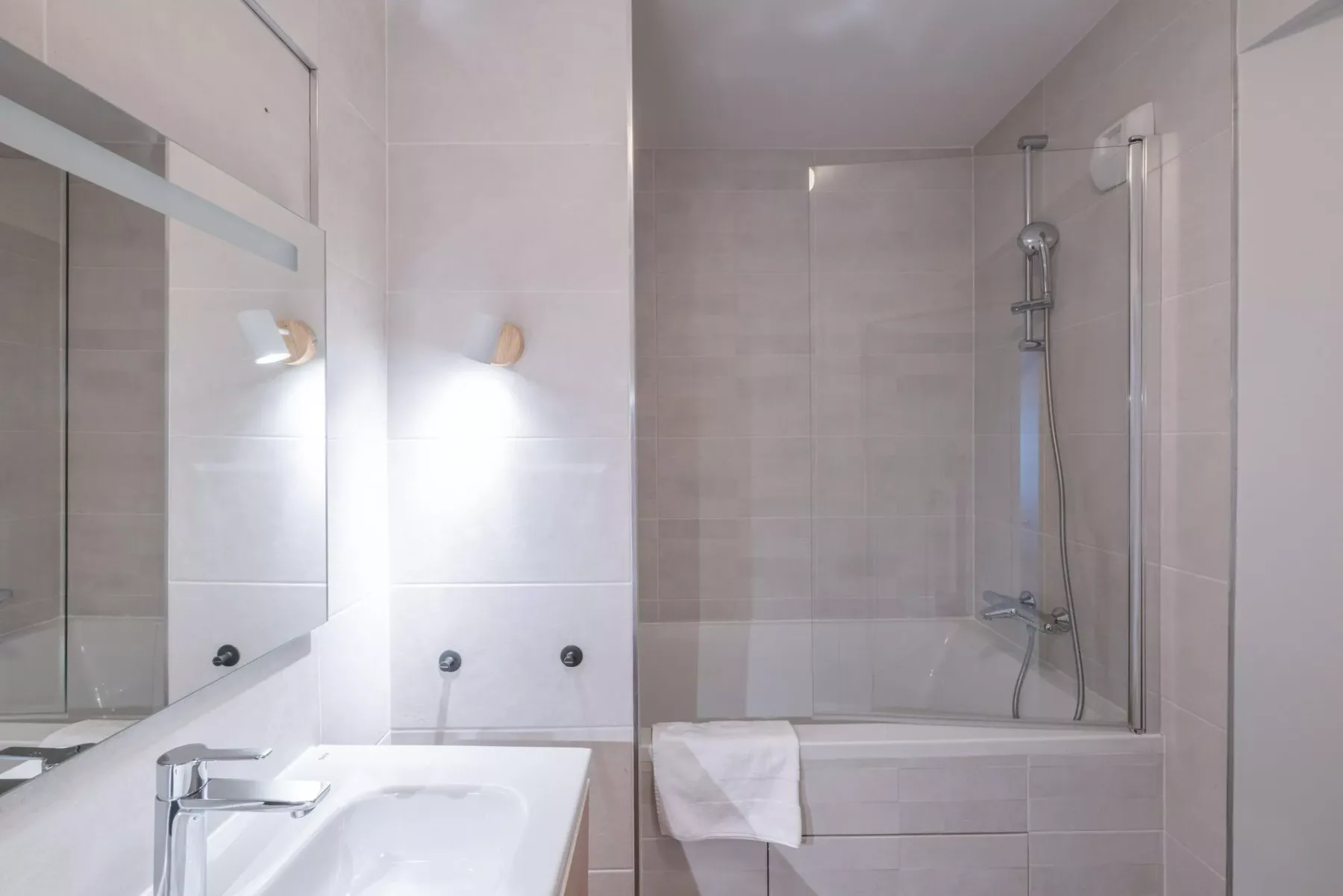 A tiled bathroom with a sink and bathtub.