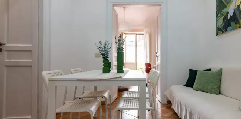Un comedor con una mesa y sillas junto a un sofá blanco.