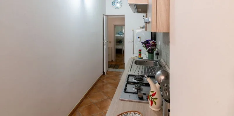 Una cocina estrecha con una estufa de gas y un fregadero junto a la encimera.