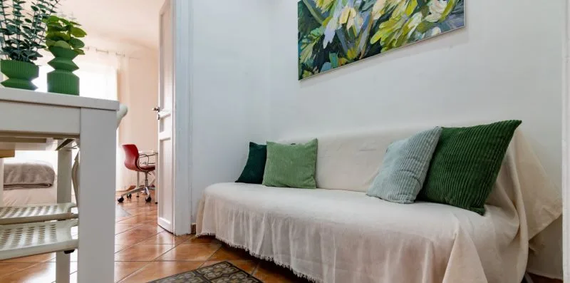 Una zona de estar con un sofá claro y una obra de arte colorida en la pared.