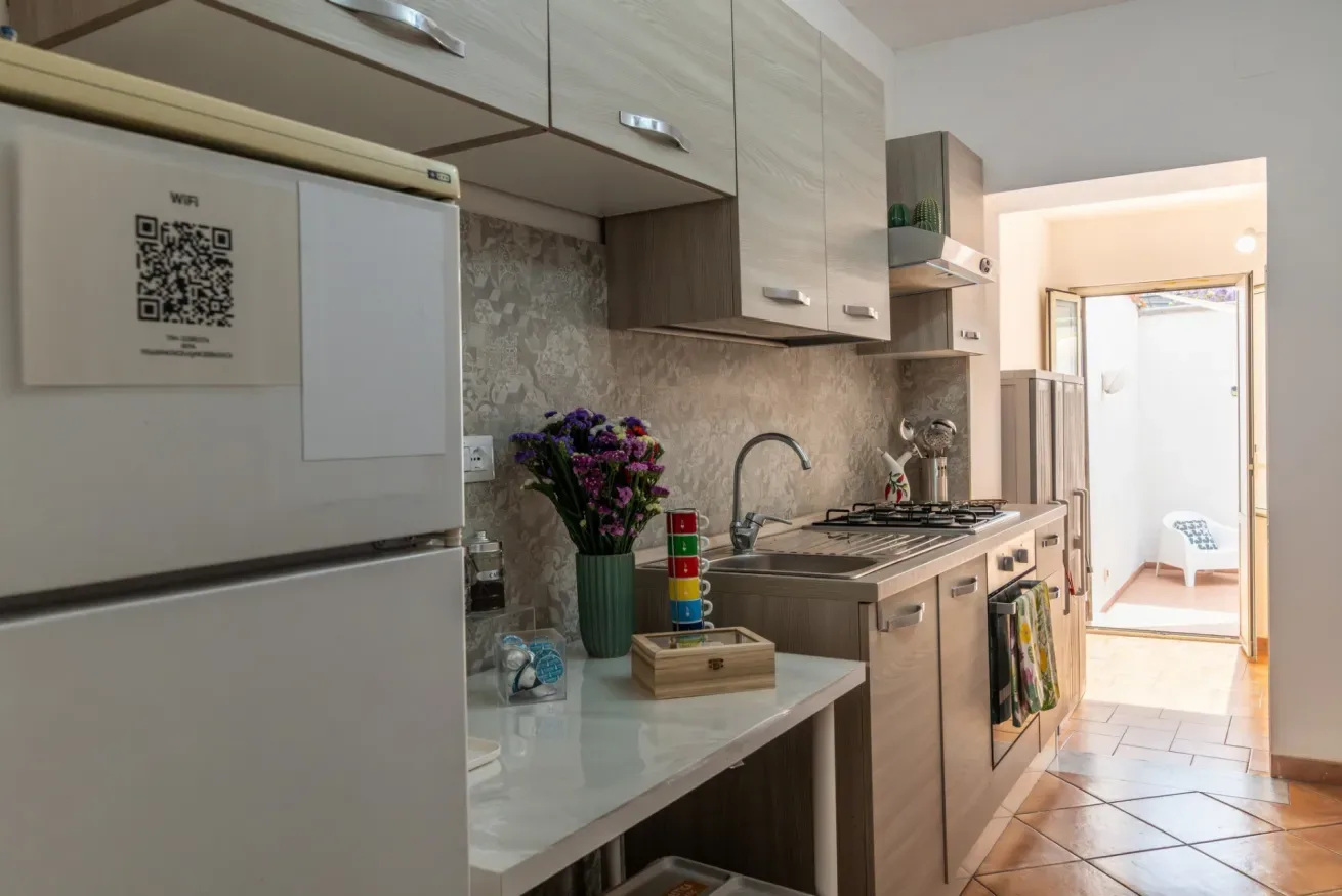 Una cocina compacta con gabinetes, una encimera y un fregadero.