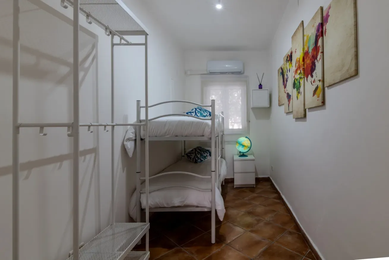 Un dormitorio con literas, cuadros coloridos y un pequeño globo.