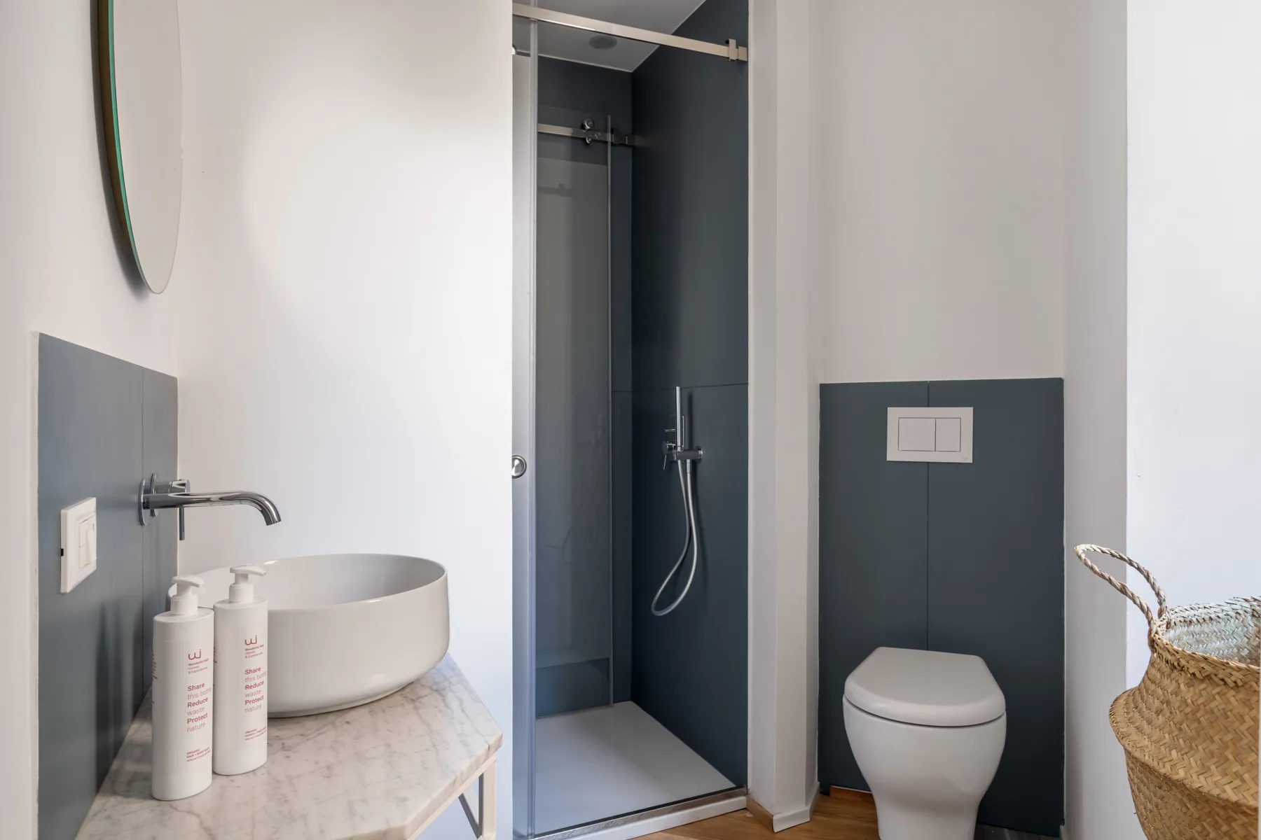 A modern bathroom with a walk-in shower, sink, and toilet.