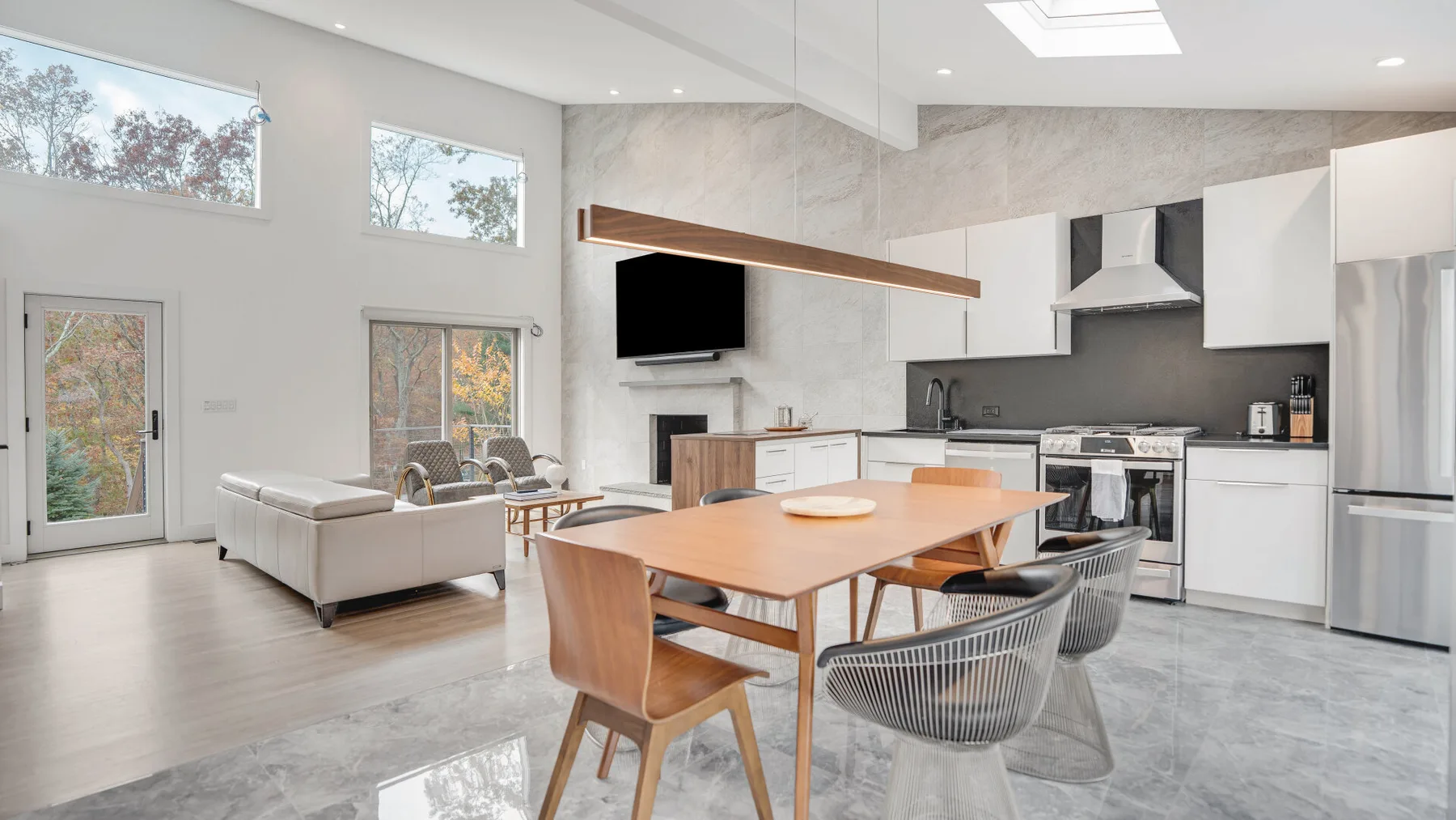 Una luminosa sala de estar y cocina de concepto abierto con una mesa de comedor.
