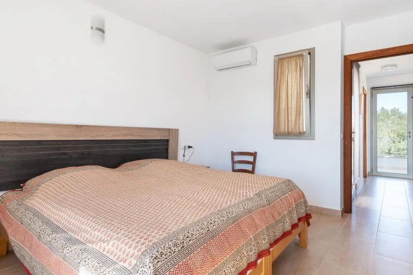 Un dormitorio con una cama cubierta con una colcha estampada.