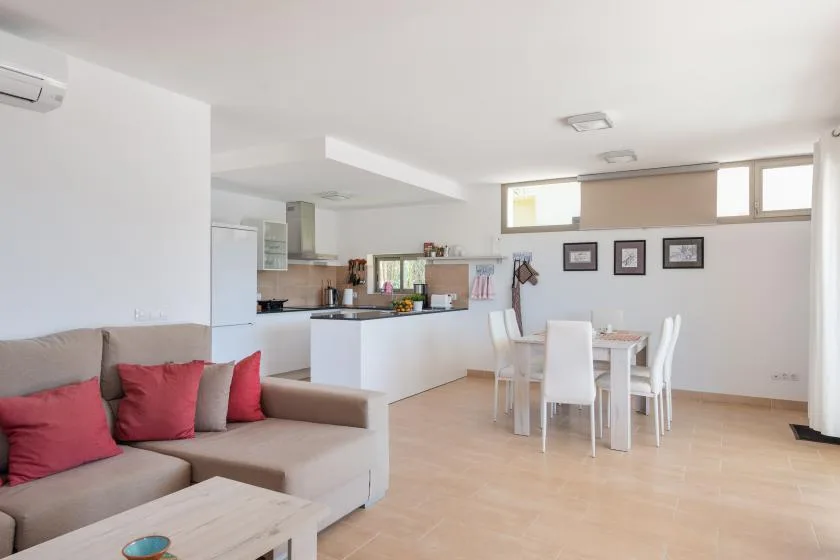 Una luminosa sala de estar y comedor se abre a una cocina compacta, con una zona de asientos.