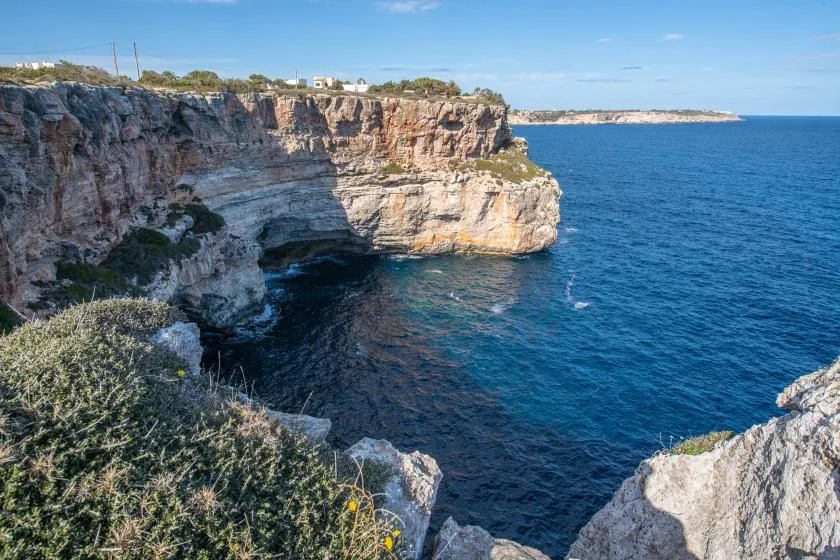 Acantilados rocosos junto al mar azul bajo un cielo despejado.