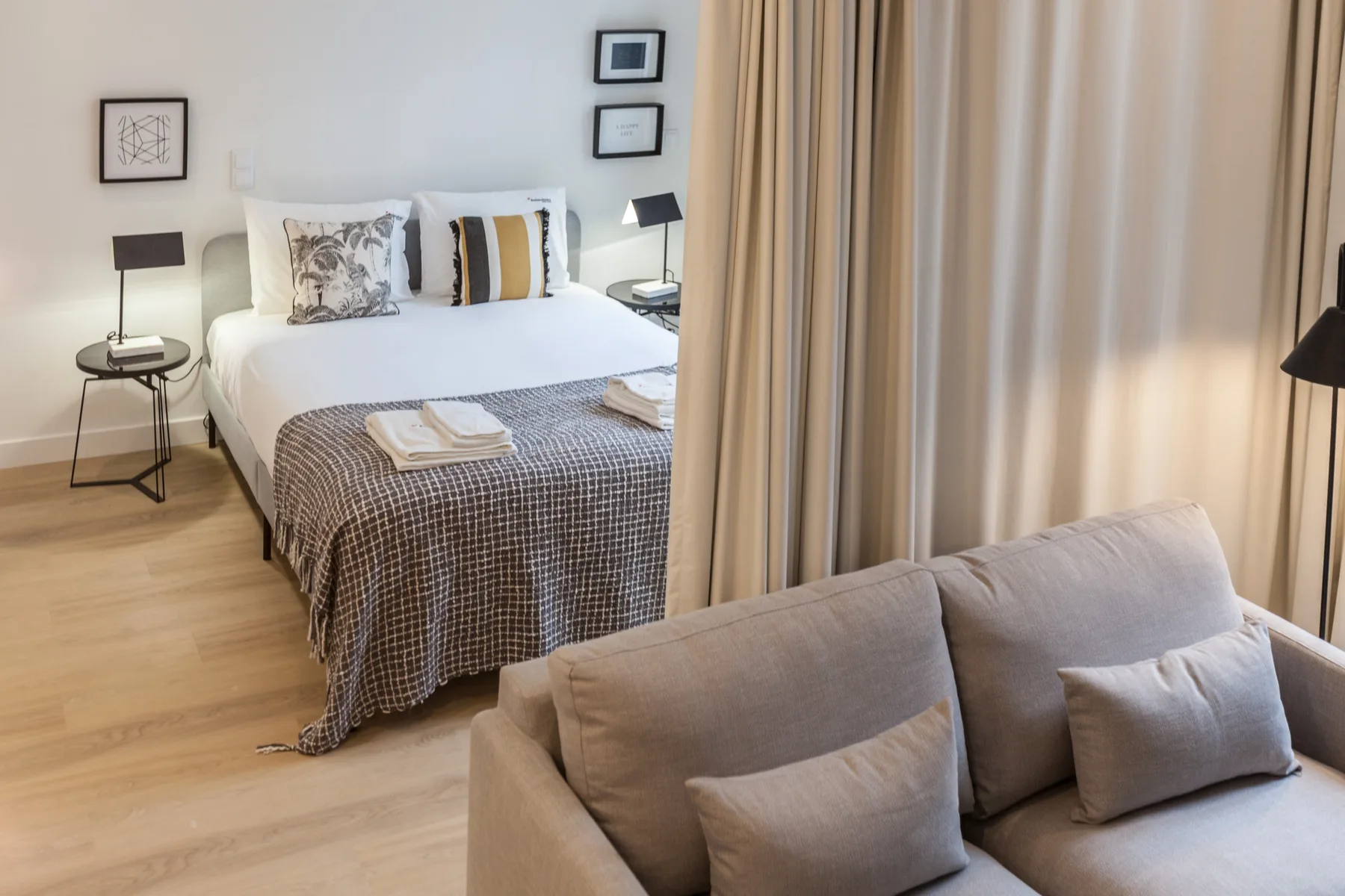 Dormitorio con una cama bien hecha y asientos en primer plano.