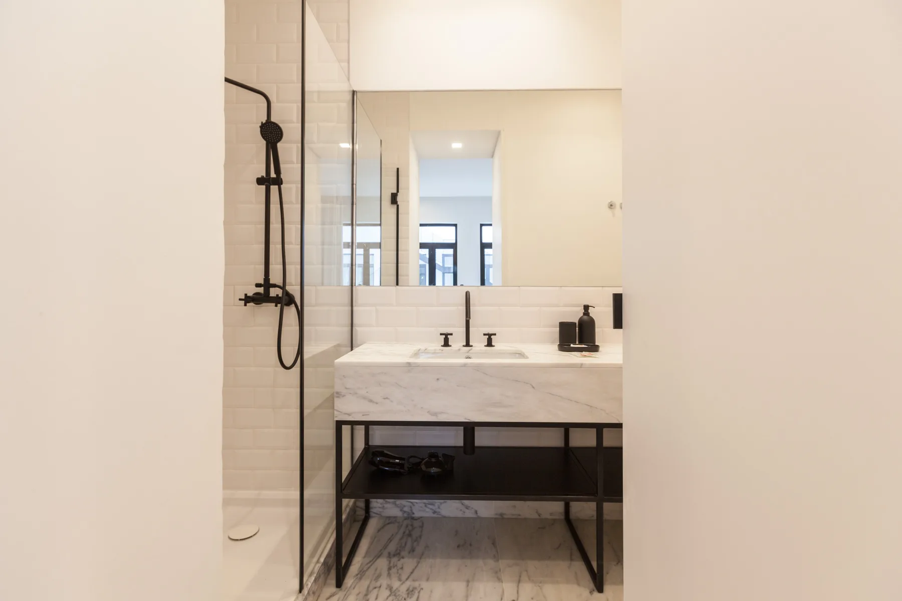 A bright bathroom with a wide vanity and a glass shower.