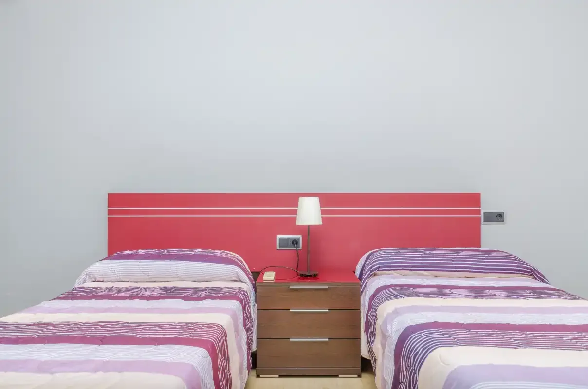 Un dormitorio con dos camas junto a una mesita de noche.