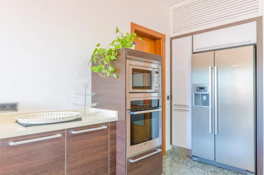Una cocina moderna con electrodomésticos empotrados y un refrigerador grande.