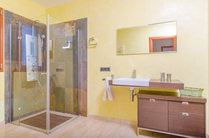 Un baño con una ducha de vidrio y un amplio mueble de lavabo.