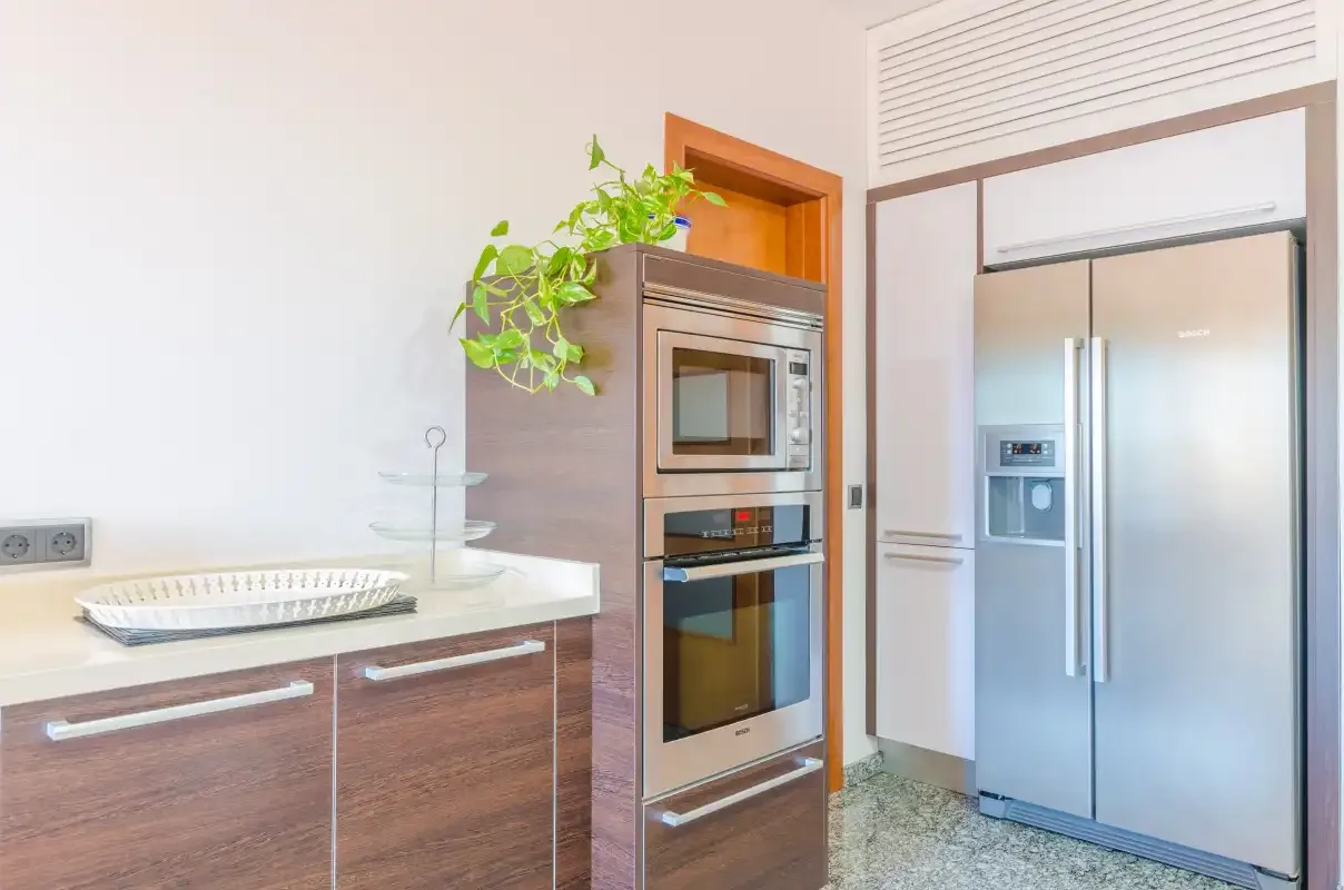 Una cocina moderna con electrodomésticos empotrados y un refrigerador de acero inoxidable.