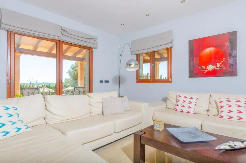 Una sala de estar luminosa con asientos claros y una mesa de centro de madera.