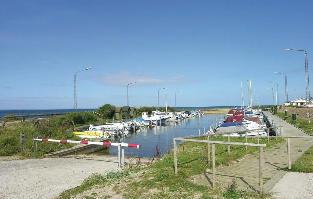A marina with boats moored along a canal beside grassy paths.