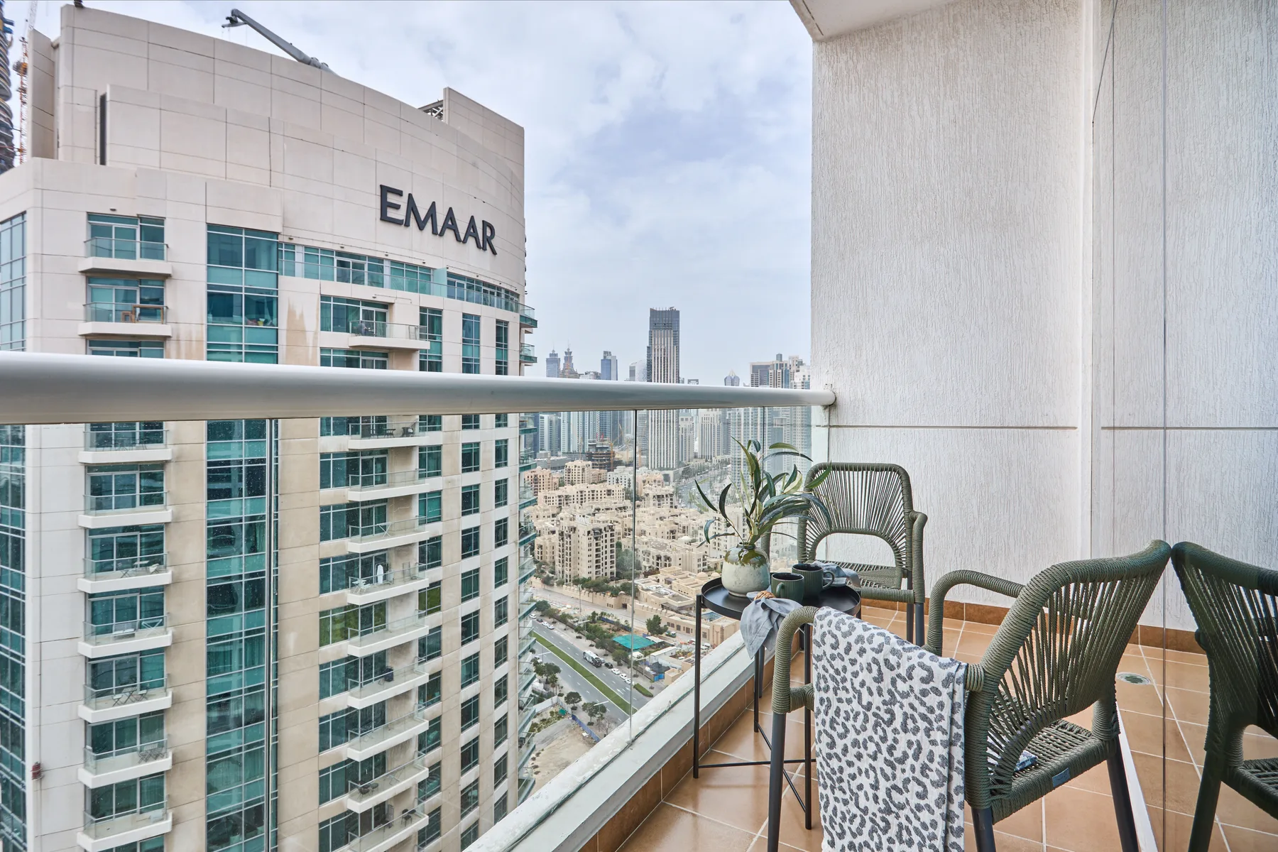 Un balcón con asientos ofrece vistas de edificios cercanos y del horizonte de la ciudad.