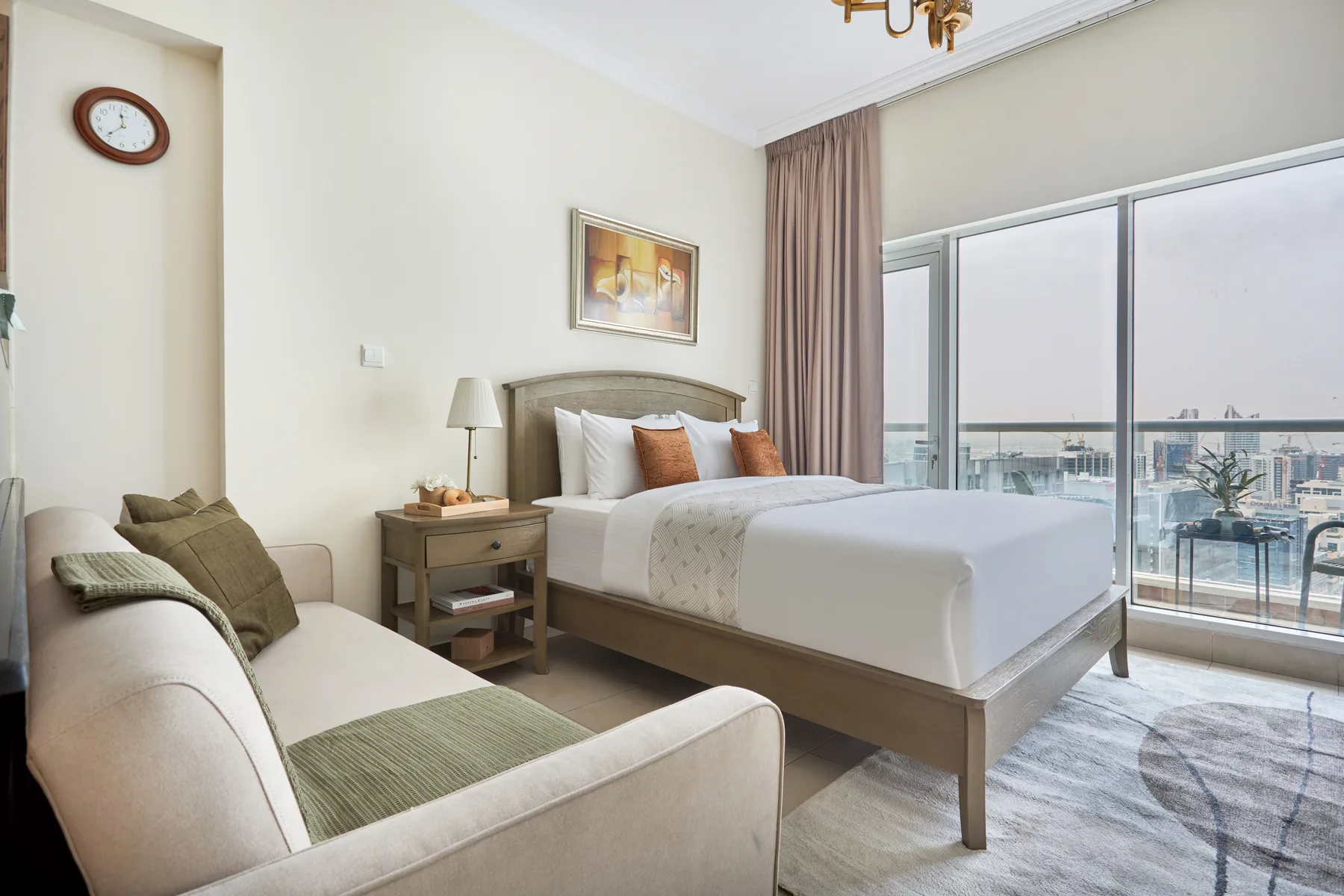 Dormitorio con una cama y asientos junto a grandes ventanales.