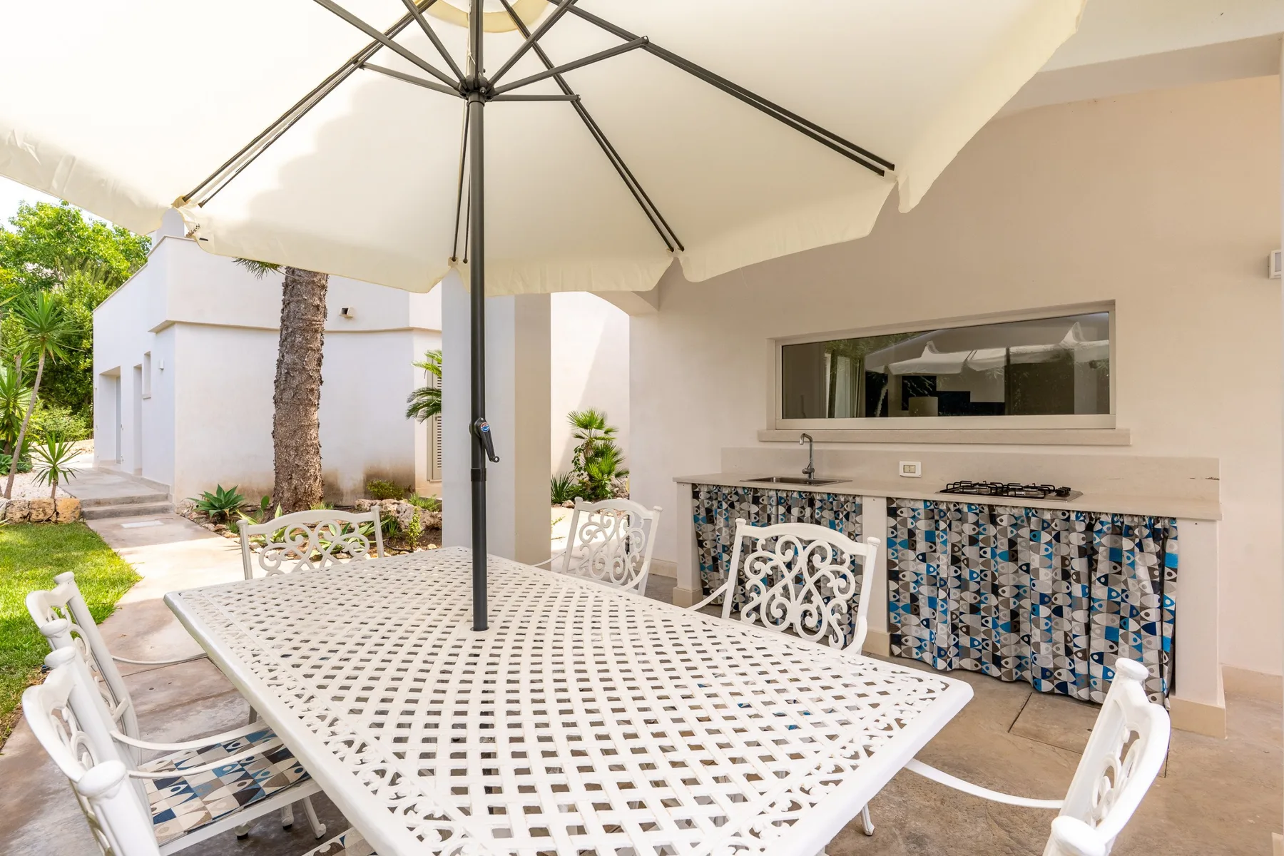 Comedor exterior cubierto con una mesa y una barra integrada.
