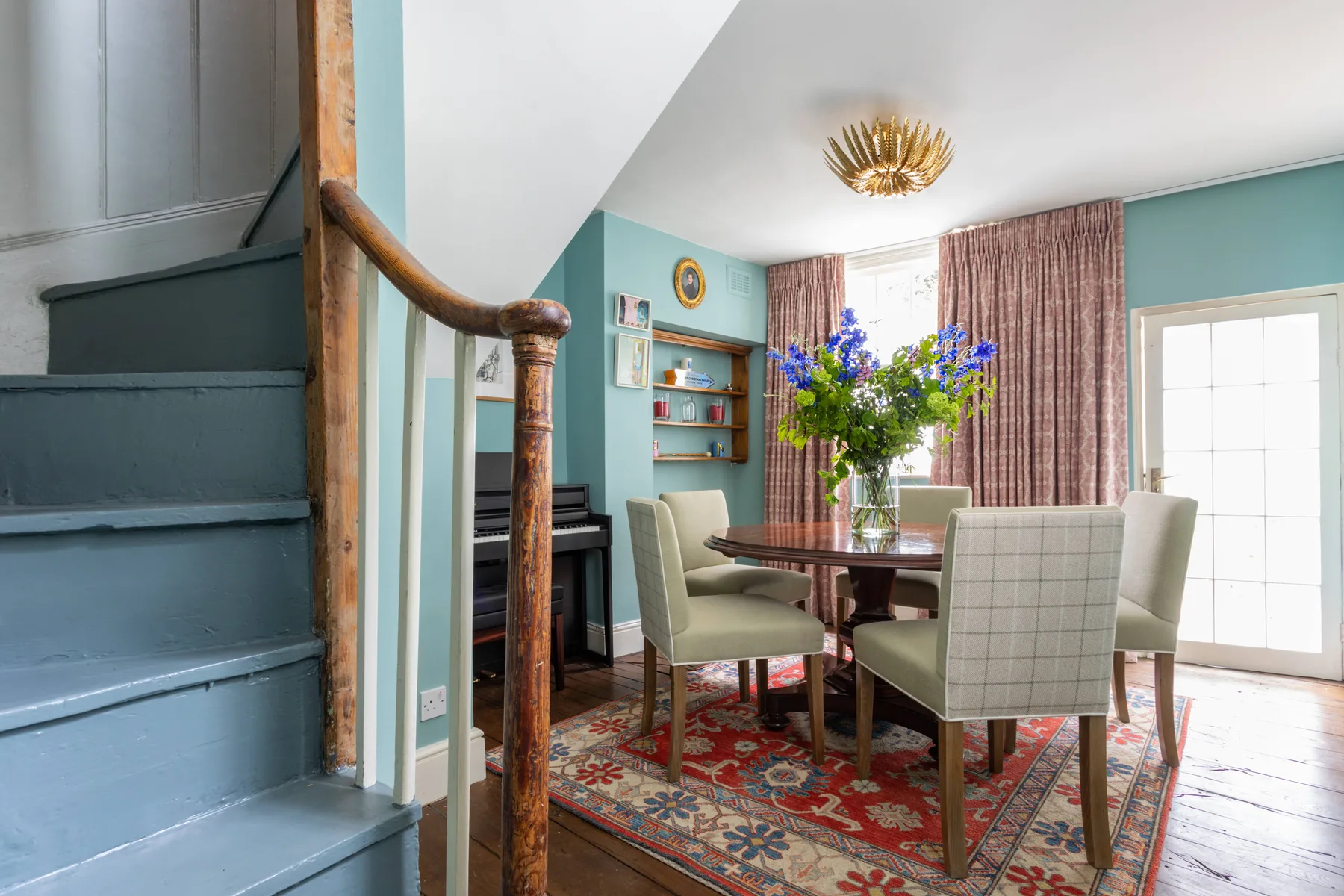 A dining area with a table, upholstered seating, and a floral arrangement.