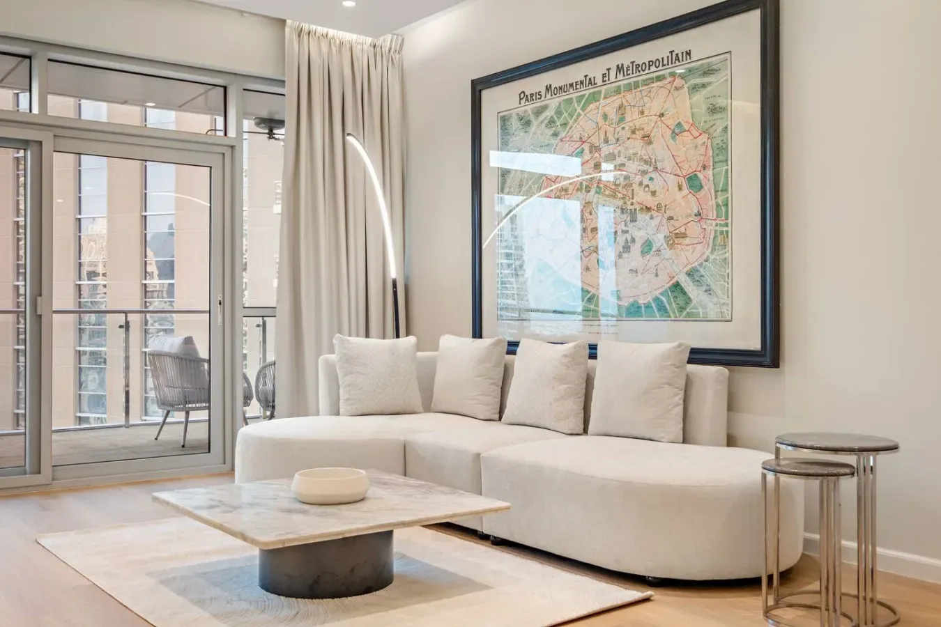 Sala de estar con una zona de asientos clara y un mapa enmarcado en la pared.