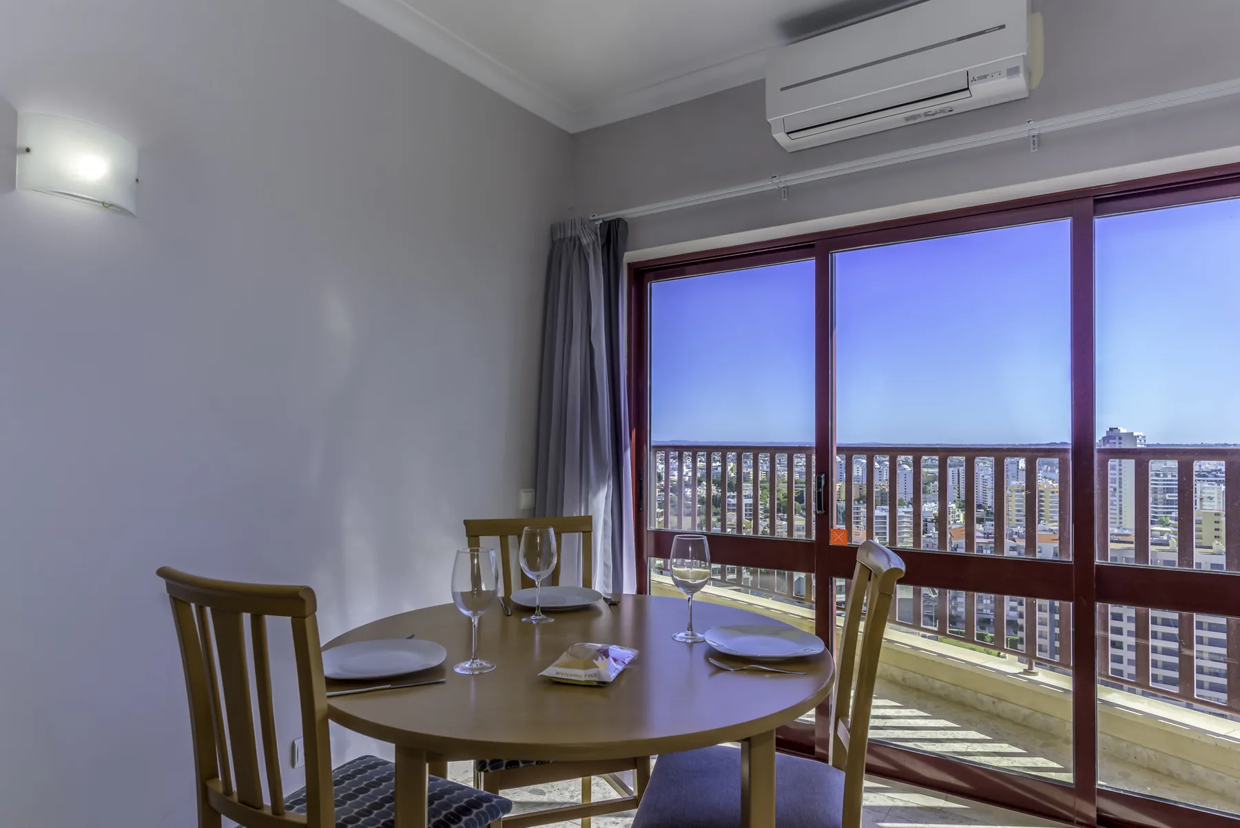 A dining area with a round table and sliding glass doors opening onto a balcony.