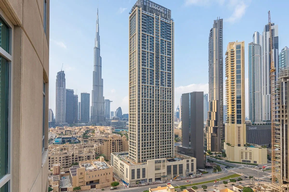 A city skyline with tall skyscrapers rises above low-rise buildings.