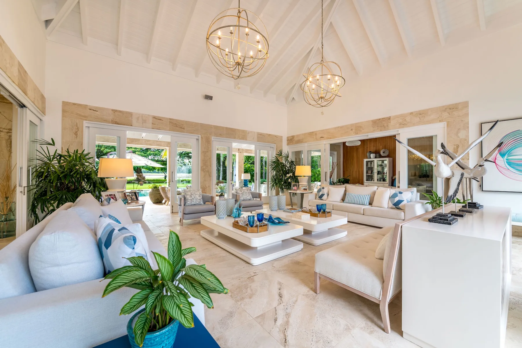 A bright living room with seating around a low central table and large windows.